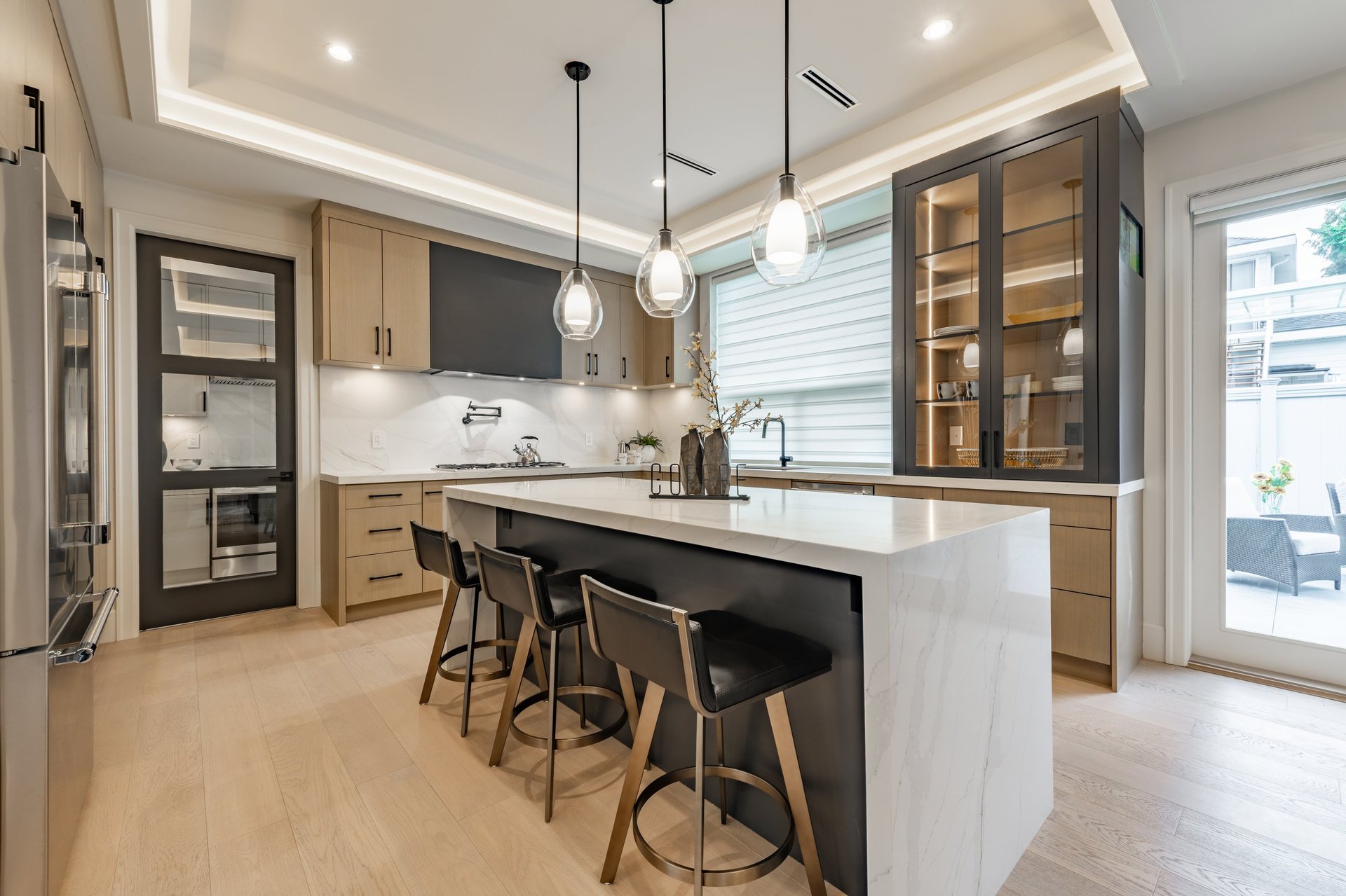 Elegant kitchen interior with bar stools, white countertops, wooden cabinets, pendant lighting