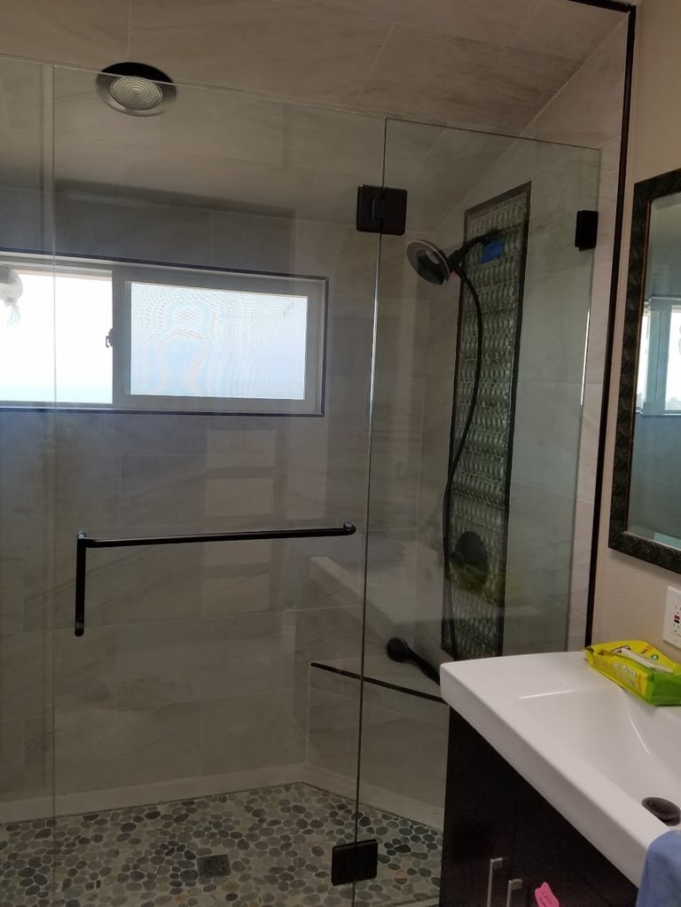 Modern glass shower enclosure with black trim and rainfall showerhead