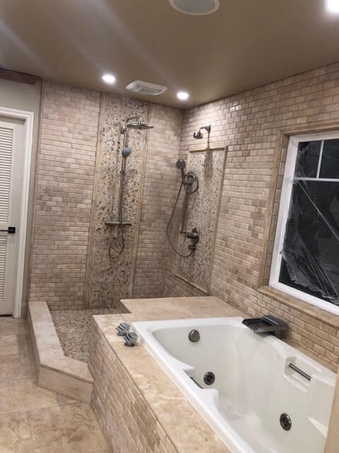 Modern luxury bathroom with double walk-in shower, soaking tub, brick tile walls