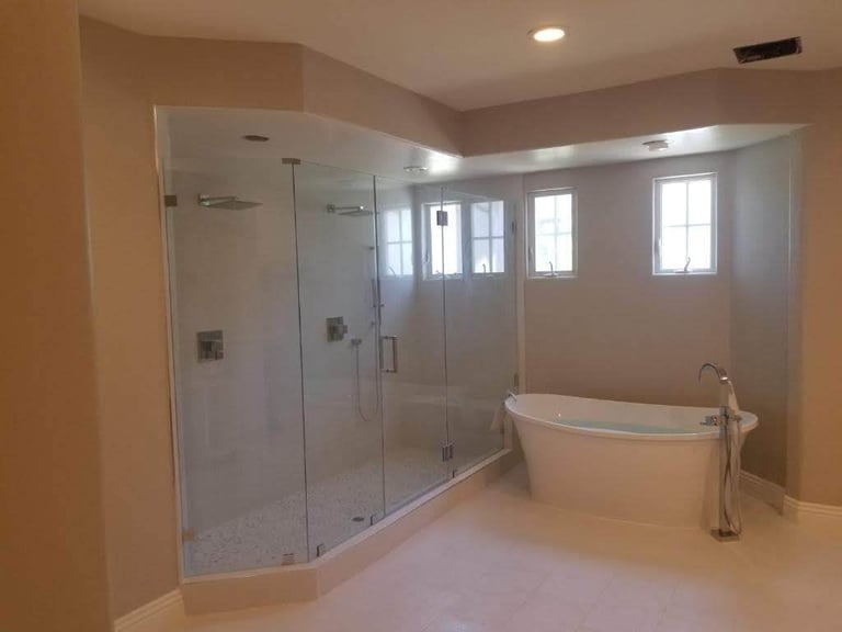 Modern bathroom with large walk-in shower, freestanding soaking tub, and neutral tile flooring